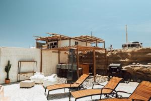 eine Gruppe von Stühlen auf einer Terrasse mit einem Haus in der Unterkunft Atenas Hotel Boutique in Paracas