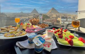 dois pratos de comida numa mesa com vista para as pirâmides em STEPS IN Pyramids View em Cairo