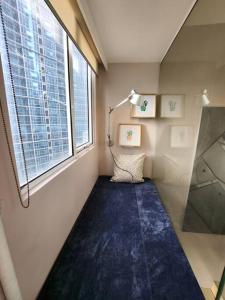 a small room with a blue rug and a window at Enjoy BGC Sunset and Golf Course View 2 BR Loft with 100mbps Internet Connection in Manila