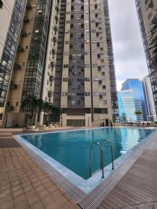 a large swimming pool in front of a tall building at Enjoy BGC Sunset and Golf Course View 2 BR Loft with 100mbps Internet Connection in Manila