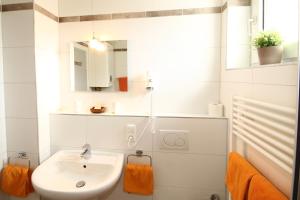 a white bathroom with a sink and a mirror at Stadthotel Jülich - Hotelwohnungen in Jülich +15 photos