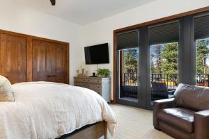 a bedroom with a bed and a chair and windows at Ultimate Luxury Residence with Extras Galore across from Heavenly Village & Gondola - Zalanta Resort in South Lake Tahoe