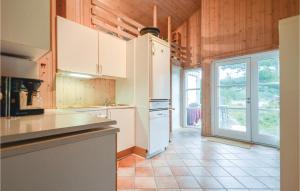 a kitchen with white appliances and a large window at Lovely Home In Rm With Kitchen in Bolilmark