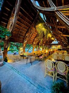 um restaurante com cadeiras e mesas e um grande telhado em The Light Hotel em Nha Trang