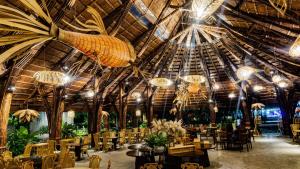 un restaurante con un gran techo con lámparas de araña y mesas en The Light Hotel, en Nha Trang