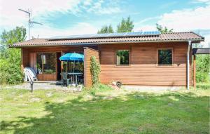 uma pequena cabina de madeira com uma mesa e um guarda-chuva em Nice Home In Dronningmlle With 2 Bedrooms And Wifi em Dronningmølle