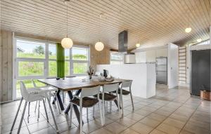 een keuken en eetkamer met een tafel en stoelen bij Nice Home In Ebeltoft With 5 Bedrooms, Wifi And Indoor Swimming Pool in Ebeltoft