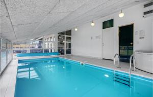 a swimming pool with blue water in a building at Nice Home In Ebeltoft With 5 Bedrooms, Wifi And Indoor Swimming Pool in Ebeltoft