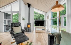 een woonkamer met een stoel en een open haard bij Nice Home In Asaa With Kitchen in Aså
