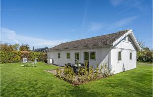 ein kleines weißes Haus mit einem Rasenhof in der Unterkunft 2 Bedroom Beautiful Home In Strby in Strøby