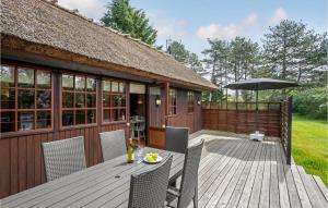 una terraza de madera con mesa y sombrilla en Pet Friendly Home In Vig With Kitchen en Vig