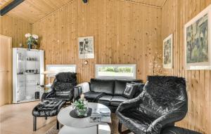 a living room with a leather couch and chairs at Sommervind in Falen