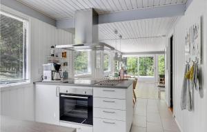 cocina con armarios blancos y fogones en Lovely Home In Nex With Kitchen, en Spidsegård