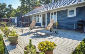 ハザスレウにあるLovely Home In Haderslev With House Sea Viewの家の上に椅子と鉢植えの植物があるデッキ
