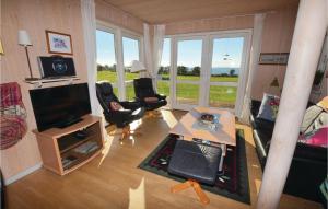 ファーボにあるStunning Home In Faaborg With 4 Bedrooms, Sauna And Wifiのリビングルーム(椅子2脚、テレビ付)