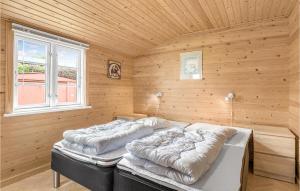 2 camas en una habitación con pared de madera en Hlzalyjkjan, en Hasle