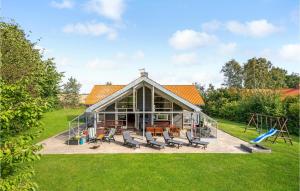 HelberskovにあるStunning Home In Hadsund With 5 Bedrooms, Sauna And Wifiの大きなガラス張りの家(椅子、遊び場付)