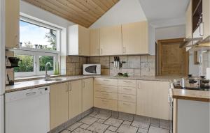 a kitchen with white cabinets and a window at Holiday Home Hadsund 02 in Hadsund