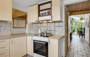 a kitchen with white cabinets and a stove at Holiday Home Hadsund 02 in Hadsund