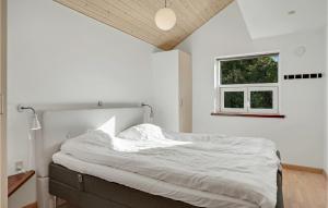 a bedroom with a bed with white sheets and a window at Holiday Home Hadsund 02 in Hadsund +24 photos