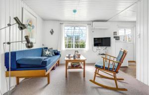 NeksøにあるStunning Home In Nex With Wifiのリビングルーム(青いソファ、椅子付)