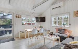 NeksøにあるStunning Home In Nex With 3 Bedrooms And Wifiのリビングルーム(ソファ、テーブル付)