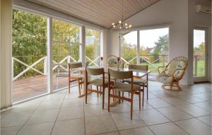 uma sala de jantar com mesa, cadeiras e janelas em Amazing Home In Lundby With Kitchen em Lundby Stationsby