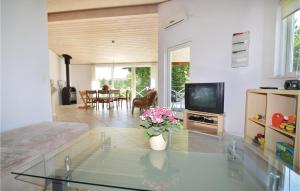 uma sala de estar com uma mesa de vidro e uma televisão em Amazing Home In Lundby With Kitchen em Lundby Stationsby