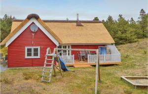 ein rotes Haus mit einem Spielplatz davor in der Unterkunft Lovely Home In Rm With Wifi in Rømø Kirkeby