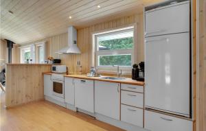 a kitchen with white cabinets and a white refrigerator at Holiday Home Lyngvej Vig Ii in Vig