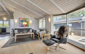 a person sitting in a chair in a living room at Stunning Home In Bog By With Sauna in Bogø By