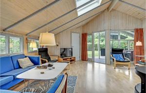 エーベルトフトにあるBeautiful Home In Ebeltoft With 4 Bedrooms And Saunaのリビングルーム(青いソファ、テーブル付)