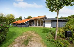 エーベルトフトにあるBeautiful Home In Ebeltoft With 4 Bedrooms And Saunaのオレンジの屋根と庭のある家