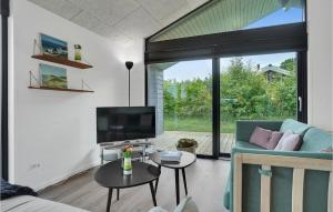 ein Wohnzimmer mit einem Sofa und einem TV in der Unterkunft 3 Bedroom Gorgeous Home In Glesborg in Fjellerup Strand