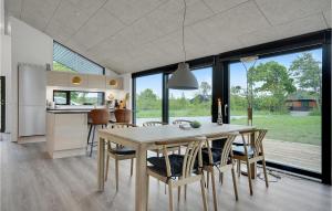 uma cozinha e sala de jantar com mesa e cadeiras em 3 Bedroom Gorgeous Home In Glesborg em Fjellerup Strand
