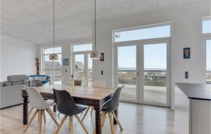 SjølundにあるAmazing Home In Sjlund With 3 Bedrooms, Sauna And Wifiのダイニングルーム(木製テーブル、椅子付)