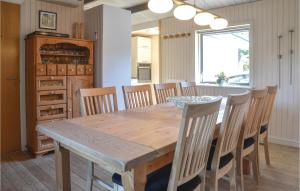 uma sala de jantar com uma mesa de madeira e cadeiras em Lrken em Vejers Strand