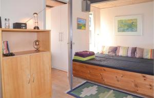 Schlafzimmer mit einem Bett und einem Holzschrank in der Unterkunft Lrken in Vejers Strand