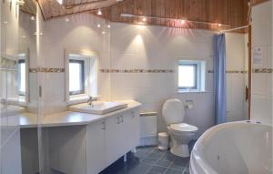 a bathroom with a sink and a toilet and a tub at Lrken in Vejers Strand