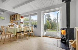 uma sala de jantar com lareira, mesa e cadeiras em Amazing Home In Holbk With Wifi em Holbæk