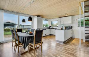 eine Küche und ein Esszimmer mit einem Tisch und Stühlen in der Unterkunft Amazing Home In Bogense With Sauna in Bogense
