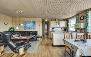 SønderbyにあるAmazing Home In Juelsminde With 3 Bedroomsのキッチン、リビングルーム(ソファ、テーブル付)