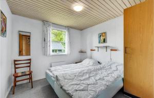 1 dormitorio con 1 cama, 1 silla y 1 ventana en Amazing Home In Juelsminde With 3 Bedrooms, en Sønderby