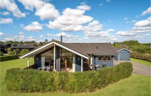 uma casa com uma sebe verde em frente em 3 Bedroom Stunning Home In Ejstrupholm em Krejbjerg