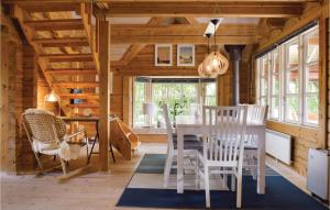 Amazing Home In Humble With Sauna في Humble: غرفة طعام مع طاولة بيضاء وكراسي