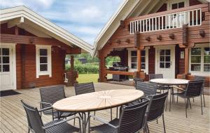 eine Terrasse mit Tischen, Stühlen und einem Grill in der Unterkunft Amazing Home In Humble With Sauna in Humble