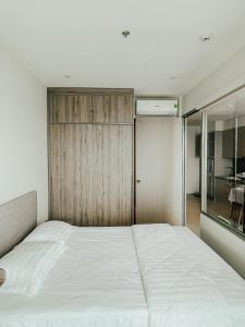 a bedroom with a white bed and a sliding door at Leo House - The Song Building 28 Thi Sách in Vung Tau
