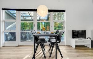 a dining room with a table and black chairs at 2 Bedroom Stunning Home In Vggerlse in Bøtø By