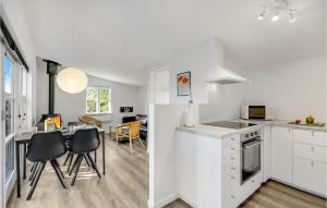 cocina y sala de estar con mesa y sillas en 2 Bedroom Stunning Home In Vggerlse, en Bøtø By