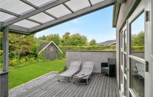 two chairs on a wooden deck with a pergola at 2 Bedroom Stunning Home In Vggerlse in Bøtø By
